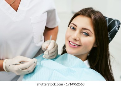 Dentist examining a patient's teeth in modern dentistry office. Closeup cropped picture with copyspace. Doctor in disposable medical facial mask. - Powered by Shutterstock