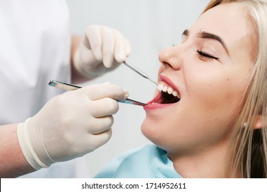 Dentist examining a patient's teeth in modern dentistry office. Closeup cropped picture with copyspace - Shutterstock ID 1714952611