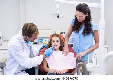 Dentist Examining Young Patient At Dental Clinic