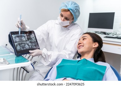 Dentist explain oral care from teeth x-ray to patient at dental clinic. Attractive woman patient lying on dental chair get dental treatment from doctor during procedure appointment service in hospital - Powered by Shutterstock