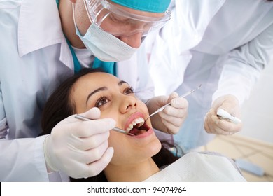 Dentist And His Assistant Carrying Out A Thorough Examination