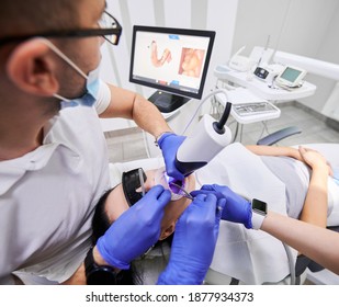 Dentist and his assistant scanning patient's teeth with modern scanning machine. Digital print of patient's teeth is on big screen. Modern high precision technologies. Concept of modern dentistry - Powered by Shutterstock