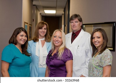Dentist and his office staff pose for a picture.