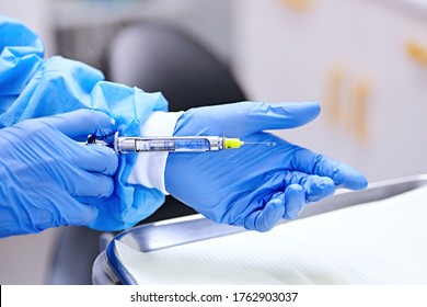 Dentist holding in her dentist's hand carpool syringe for local anaesthesia 