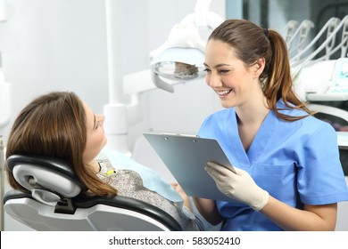 Dentist holding a medical history asking information to a patient before treatment sitting on a chair in a box - Powered by Shutterstock