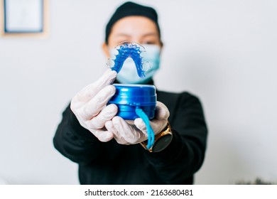 A dentist holding retainers, Female dentist holding dental retainers, Portrait of a female dentist holding retainers - Shutterstock ID 2163680481