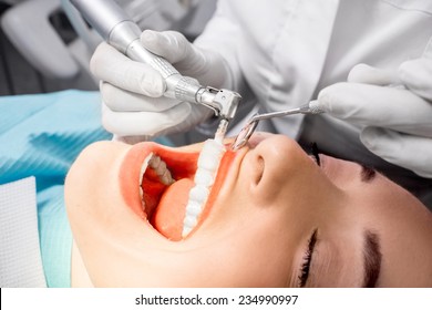 Dentist Making Professional Teeth Cleaning Female Young Patient At The Dental Office. Close-up Plan