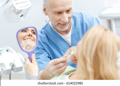 Smiling Female Dentist Explaining Artificial Teeth Stock Photo (Edit ...