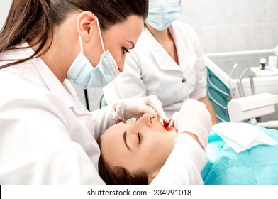 Dentist And Nurse Making Professional Teeth Cleaning Female Young Patient At The Dental Office