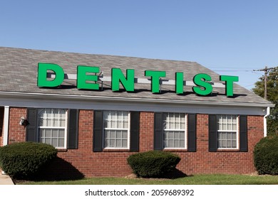 Dentist Office Exterior With Green Text And Brick Background.