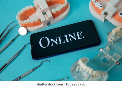 Dentist Online Appointment. Phone With Medical Instruments And Jaw Isolated On The Blue Background.