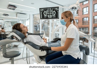 Dentist and patient choose treatment during consultation with medical equipment in dentistry. the right solution for the treatment of the oral cavity - Powered by Shutterstock