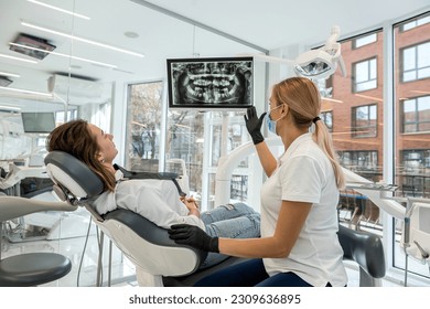 Dentist and patient choose treatment during consultation with medical equipment in dentistry. the right solution for the treatment of the oral cavity - Powered by Shutterstock