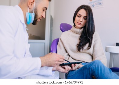 Dentist And Patient Look Together On X-ray Image Of The Dentition On A Phone. Dentistry And Healthcare Concept.