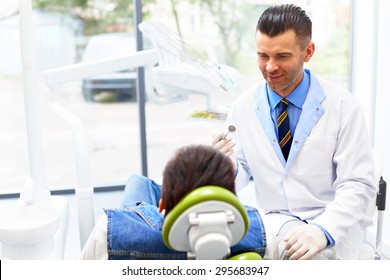 Dentist And Patient In Dentist Office. Young Man In The Dental Chair. Dental Treatment