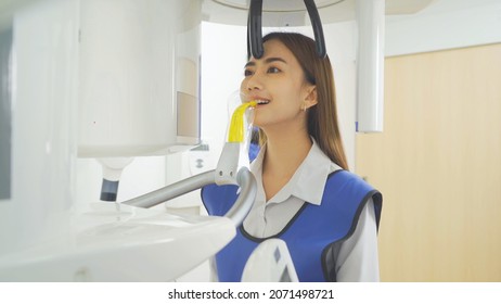 A dentist, people having dental X-Ray on machine technology device to Asian patient woman in lab. Teeth examine. Doctor. Dentistry, medical and dental health scan test.