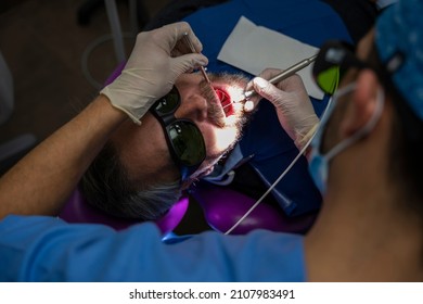 Dentist Performing A Laser Treatment On A Patient