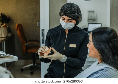 Dentist presenting a dental model and explaining procedure details to a patient.