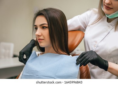 Dentist Puts A Bib On A Patient