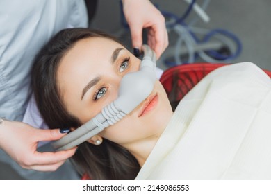 dentist puts inhalation sedative mask on his patient. - Shutterstock ID 2148086553