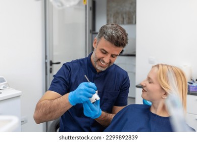 Dentist showing dental plaster mold to the patient. Dentist doctor showing jaw model at dental clinic, dental care concept. Dental care concept. - Powered by Shutterstock