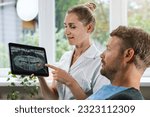 dentist showing and explaining dental x-ray picture with impacted wisdom tooth to his patient