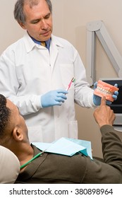 Dentist showing patient how to clean teeth - Shutterstock ID 380898964