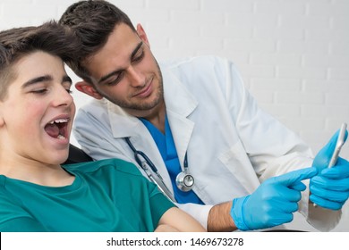 Dentist Showing The Patient On The Mobile Phone