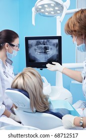 Dentist Shows A Patient X-ray Of Teeth