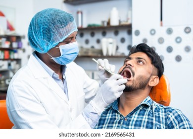 dentist with surgical gloves and face mask checking teeth of patient at hospital or clinic - concept of oral care, hygienist and professional occupation. - Powered by Shutterstock