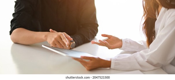 Dentist talking and giving an advice about oral health care to male patient at dental clinic. cropped image - Powered by Shutterstock