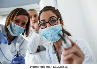 Dentist Team In Dental Office Examining Patient Teeth.Camera Angle From Patients Perspective.