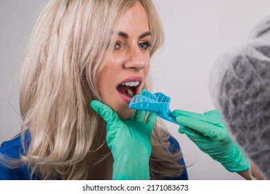 Dentist Using Dental Impression Tray On Woman Teeth