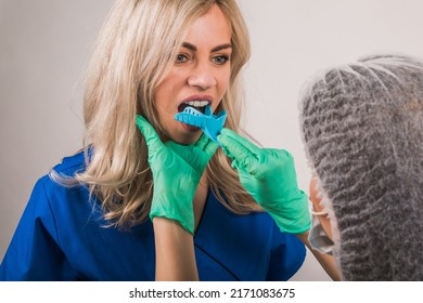 Dentist Using Dental Impression Tray On Woman Teeth