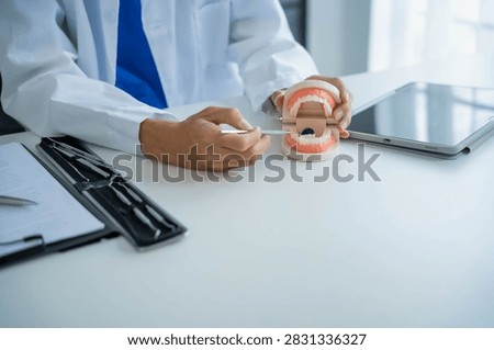 Dentist using equipment with teeth model.