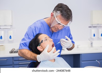 Dentist Wearing Face Shield And Doing Injection To His Patient In Dental Clinic