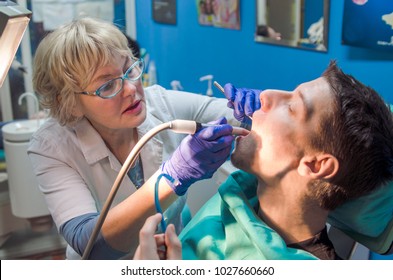 Dentist Woman Fix Young Man Patient Teeth In Dental Office.Busy Dental Girl Doctor At Work.