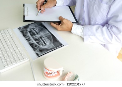 Zahnarztarbeit auf dem Tisch mit Denture und Zahnröntgen-Papier für die Mundgesundheit
