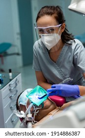 Dentistry Under General Anesthesia. The Dentist Treats The Patient Under General Anesthesia. Dentist And Assistant In The Process.