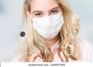 Dentist's Assistant Or Female Dentist With Dental Face Mask Shows Dental Instrument