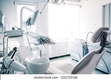 Dentist`s Chair In Modern Well Lit Ambient. No People, Just The Office. Desaturated Photo For More Business Like Feel.