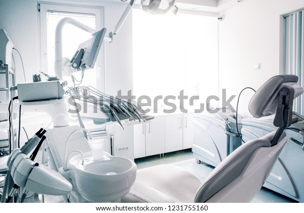 Dentist`s\
chair in modern well lit ambient. No people, just the office.\
Desaturated photo for more business like\
feel.