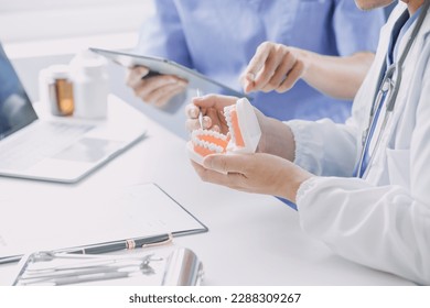 Dentists are discussing dental problems at report x-ray image on laptop screen to patients. - Powered by Shutterstock