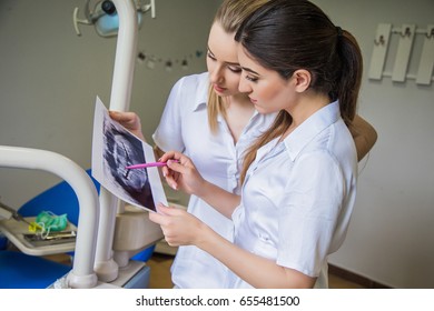 Dentists discussing X-rays photo. Dentist teaching. Healthy teeth. Oral hygiene. Dental surgery