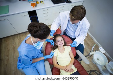 Dentists examining a young patient with tools in dental clinic
