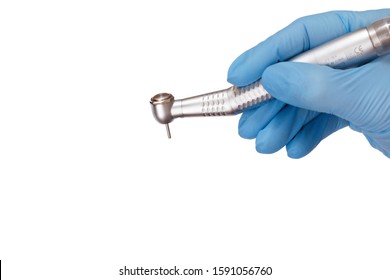 Dentist's hand in a latex glove with new high-speed dental handpiece on white isolated background. Medical tools concept.
