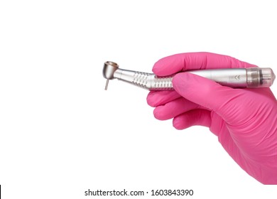 Dentist's hand in a latex glove with new high-speed dental handpiece on white isolated background. Medical tools concept.
