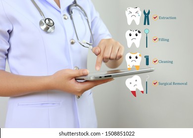 Dentist's using tablet smart device with icon set of teeth treatment and problem of tooth loss on white background, Dentistry and Tooth hygiene concept