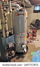 Denver, CO, USA, April 5, 2020. Plumber Installed This Brand New Hot Water Heater In This Basement After The Old Water Heater Broke And Leaked All Over The Basement. Calling A Plumber Is Expensive. 