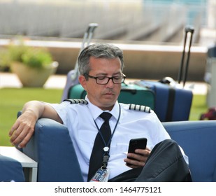 Denver, CO, USA. July 27, 2019. Unidentified Flight Crew Member Taking Relaxing Between Flights To Text Friends And Family Members At Denver International Airport. 